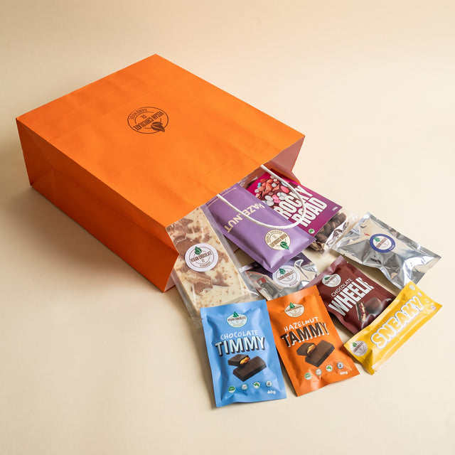 Mega All-Favourites Gift Bag: the chocolates spilling out of the orange Vegan Chocolate Co gift bag