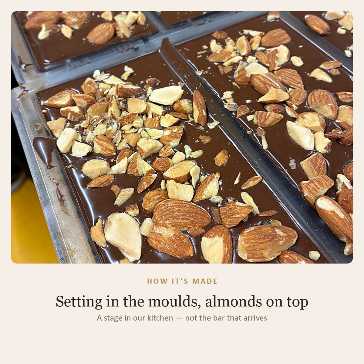 How it is made: the almond bars setting in their moulds with roasted chopped almonds scattered over the chocolate — a stage in the kitchen, not the finished bar