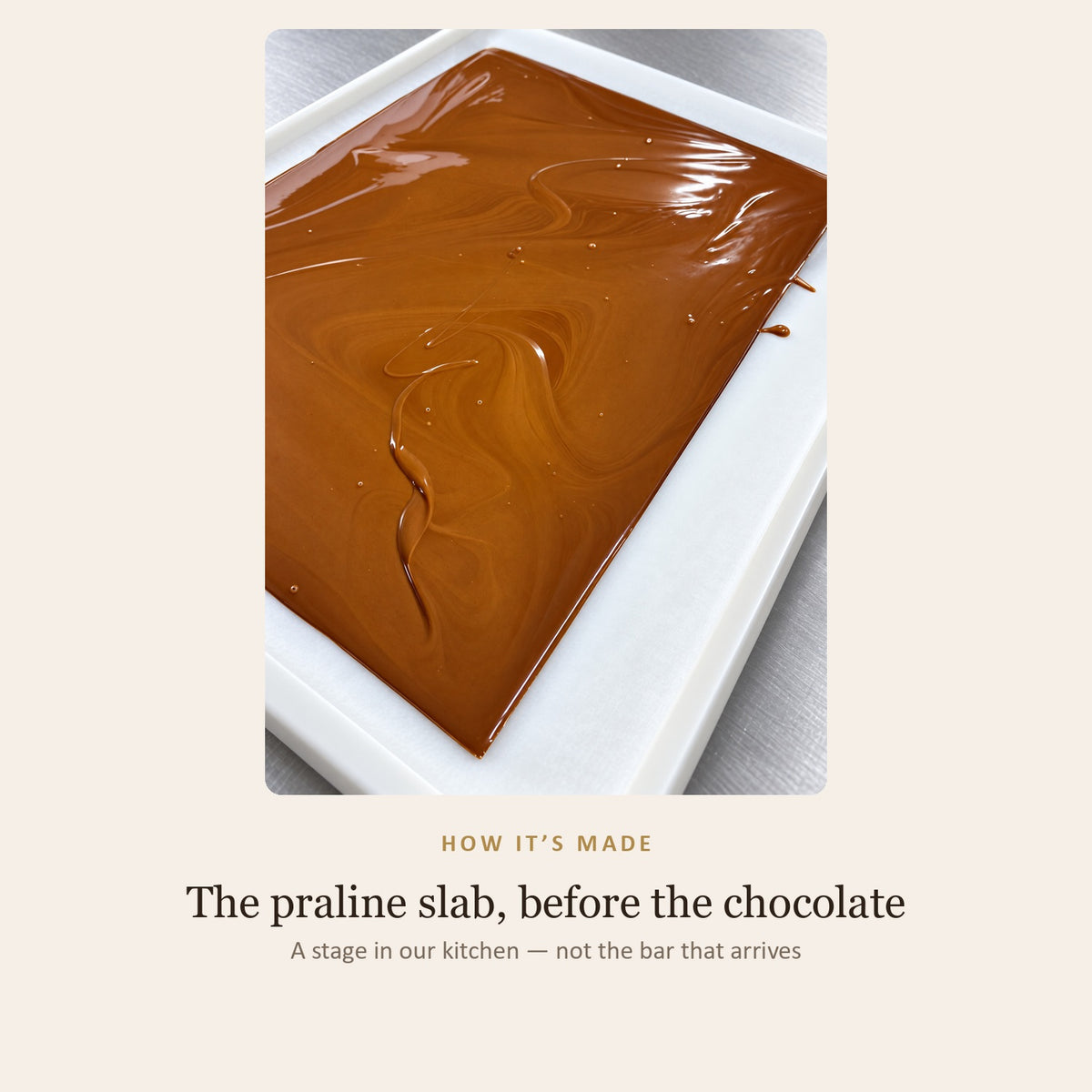 How it is made: a tray of praline poured out and setting, glossy and swirled, before it is cut and coated in chocolate — a stage in the kitchen, not the finished bar