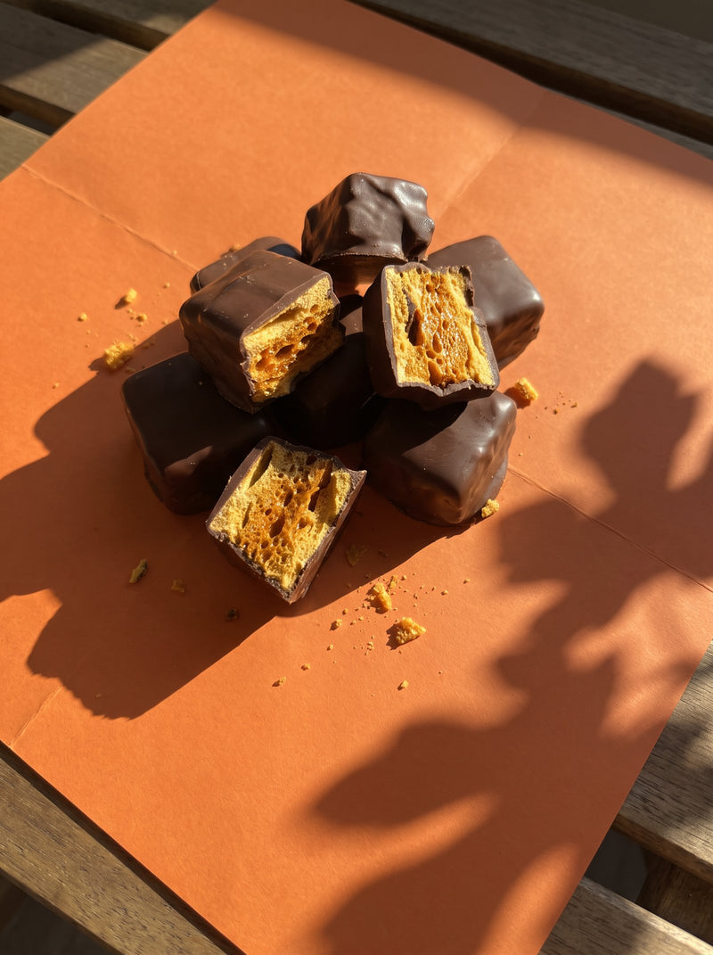 Chocolate coated honeycomb on orange paper