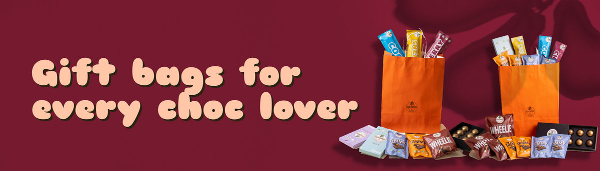 Gift bags for every choc lover: two orange Vegan Chocolate Co gift bags filled with Wheelies, Timmys, Tammys, bars and bon bons